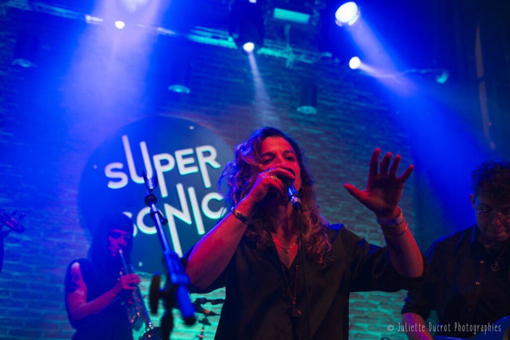 Aline en train de chanter pendant un concert de Lorsque les Volcans Dorment