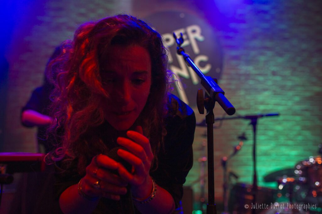 Aline en train de chanter pendant un concert de Lorsque les Volcans Dorment